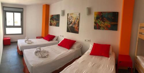 
a hotel room with two beds and a painting on the wall at New Art Hostel - Albergue Juvenil in Palma de Mallorca
