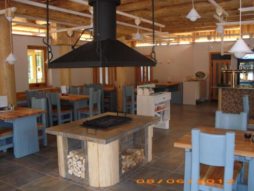 a restaurant with a fireplace in the middle of the room at Penzion U Fábů in Lednice