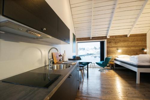 a kitchen with a sink and a bed in a room at Hattvika Lodge in Ballstad