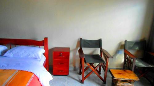 a bedroom with a bed and a desk and a chair at Cactus Eco Camp and Lodge in Elmenteita