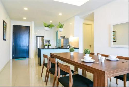 a dining room and kitchen with a wooden table and chairs at Relax & Chill at Malacca River in Melaka