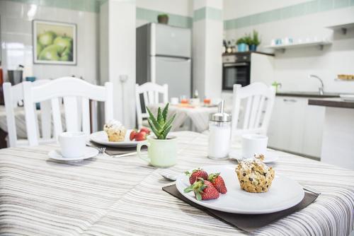 a table with plates of food and strawberries on it at B&B casa73 in Cicerale