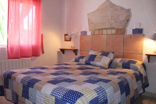 a bedroom with a bed with a checkered blanket at Finca Doña Sofia Maria in San Pedro del Pinatar
