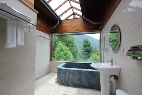 a bathroom with a shower and a sink and a window at Pei Kong Creek Resort in Guoxing
