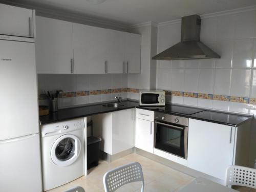 a kitchen with white cabinets and a washer and dryer at Vivienda Briviesca La Vega in Briviesca