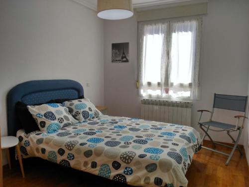 un dormitorio con una cama y una silla en Vivienda Briviesca La Vega, en Briviesca