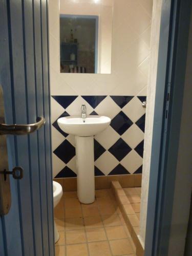 ein Bad mit einem Waschbecken und einem Spiegel in der Unterkunft Lemon Tree Cottage in Finikounda