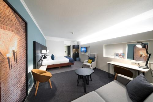 a hotel room with a bed and a living room at Bilderberg Kasteel Vaalsbroek in Vaals
