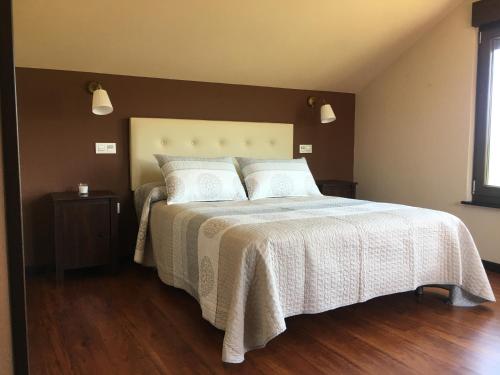 1 dormitorio con 1 cama con colcha blanca en Chalet La Caleya, en Otur