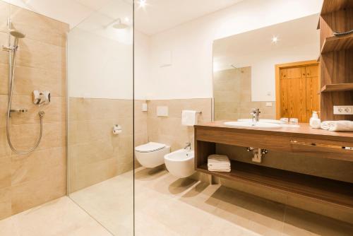 a bathroom with a toilet and a sink and a shower at Hotel Theresia in San Leonardo in Passiria