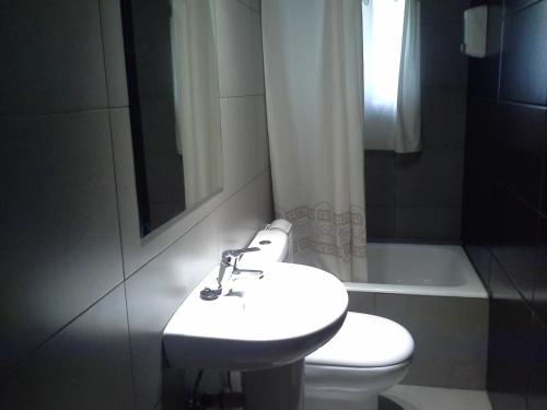 ein Badezimmer mit einem Waschbecken, einem WC und einer Badewanne in der Unterkunft Pensión Lacasta in Saragossa