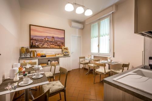 um restaurante com mesas e cadeiras num quarto em B&B Antiche Armonie em Florença