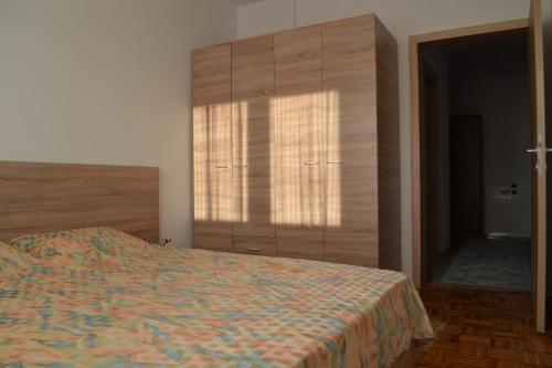 een slaapkamer met een bed en een grote houten kast bij Apartment Gashi in Pristina