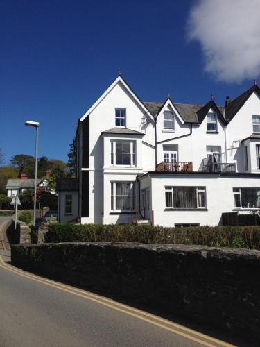 a white house on the side of a street at Tirionfa Guest House in Criccieth