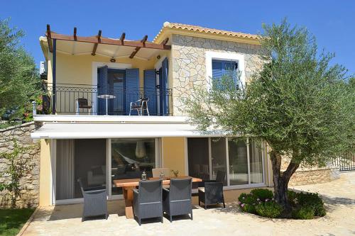 a house with a table and chairs in front of it at Fairway Villas, A Terra Lusso Property in Gialova