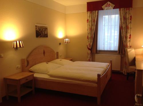Schlafzimmer mit einem Bett und einem Fenster in der Unterkunft bei Zwillings Hotel & Restaurant in Hilbersdorf