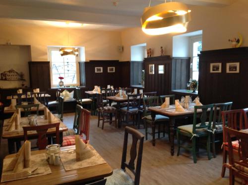 bei Zwillings Hotel & Restaurant في Hilbersdorf: غرفة طعام مع طاولات وكراسي خشبية