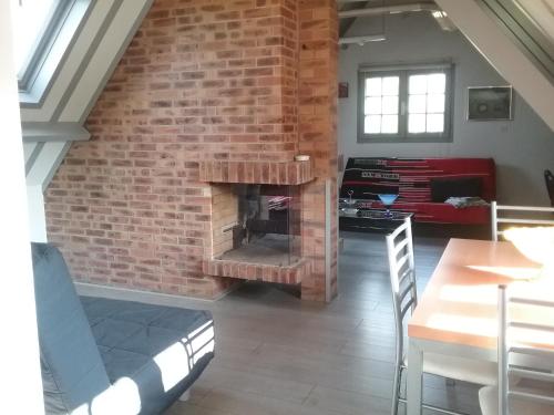 - un salon avec un mur en briques et une cheminée dans l'établissement Gîte de l'Augérois, à Fatouville-Grestain