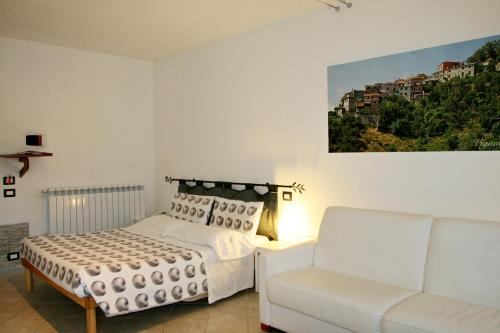 a white bedroom with a bed and a couch at Costa Morroni in Levanto