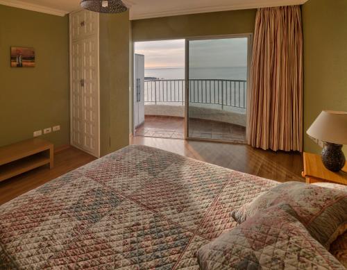 - une chambre avec un grand lit et un balcon dans l'établissement Sunset, à Icod de los Vinos