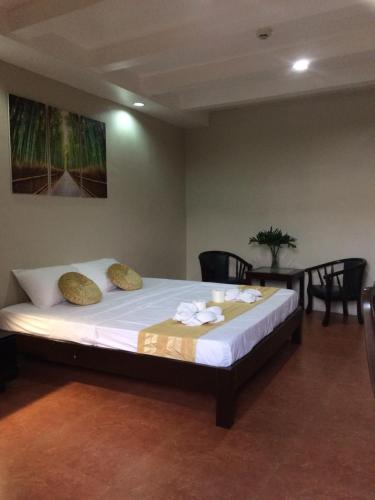 a large bed in a room with chairs and a table at Mañana Hotel in Olongapo