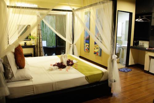 a bedroom with a bed with white sheets and curtains at Sulu Sea Boutique Hotel in Boracay