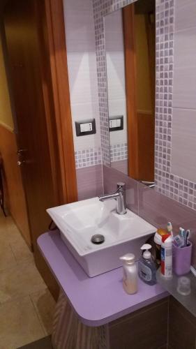 La salle de bains est pourvue d'un lavabo blanc et d'un miroir. dans l'établissement Nel cuore del Centro, à Salerne