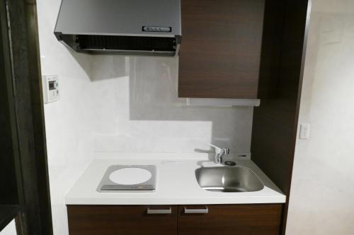 a small kitchen with a sink and a stove at La cura in Takayama