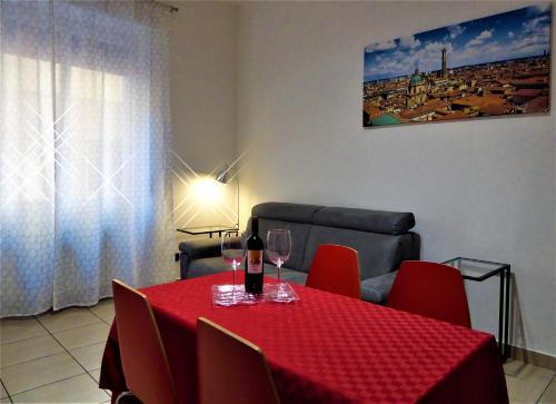 ボローニャにあるMontebello House Bolognaのテーブル(赤い椅子付)とワイングラス
