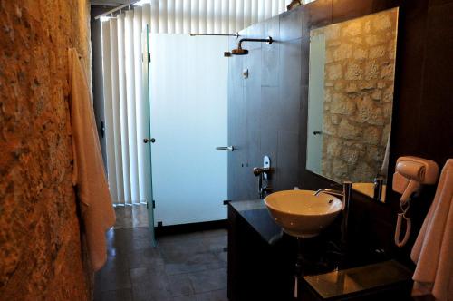 a bathroom with a sink and a shower with a mirror at Leivatho Hotel in Svoronata