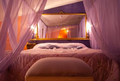 sypialnia z łóżkiem z baldachimem i lustrem w obiekcie Amarcord w mieście Bagnoregio