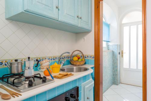 a kitchen with a sink and a stove top oven at Appartamenti Baia di Citara in Ischia