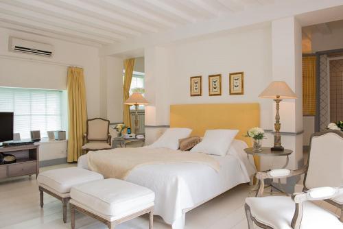 a white bedroom with a large bed and a desk at Château de Courban and Spa Nuxe in Courban