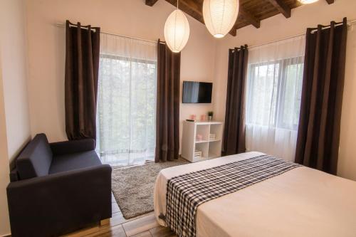 a bedroom with a bed and a chair in front of a window at Friends Bungalows in Kŭrdzhali