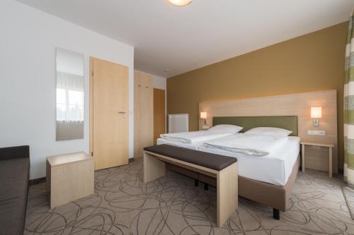 a hotel room with two beds and a desk at Hotel SCHNEIDER in Allersberg