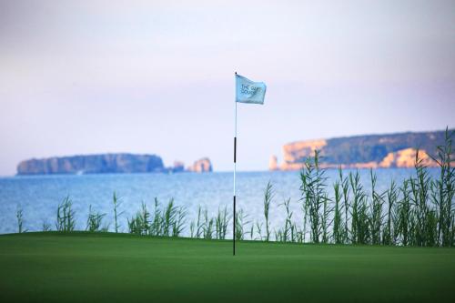 a flag on a golf course next to the water at Fairway Villas, A Terra Lusso Property in Gialova