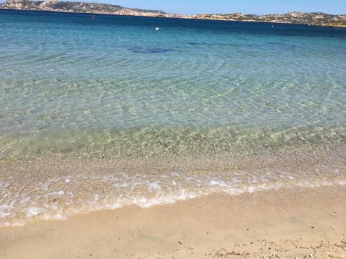 a body of water with a sandy beach and the ocean at Le 9 Gocce Seaview Apartment in Palau