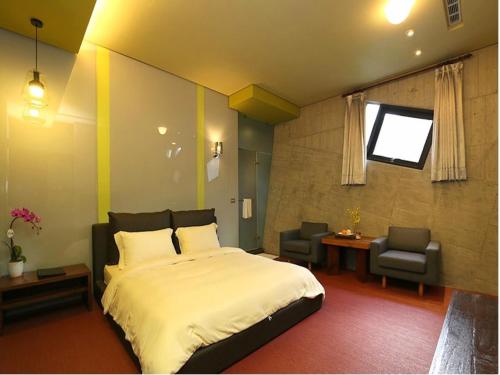 um quarto com uma cama, uma secretária e uma cadeira em Smoking Rock em Jiaoxi