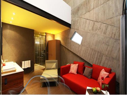 uma sala de estar com um sofá vermelho e uma casa de banho em Smoking Rock em Jiaoxi