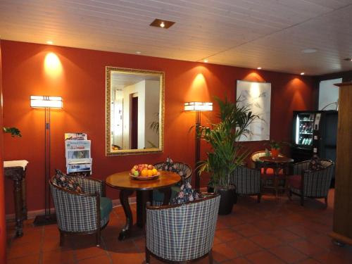 a restaurant with a table and chairs and a mirror at Hotel Schlössli Garni - Free Parking in Ipsach