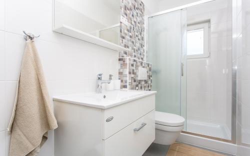 uma casa de banho branca com um lavatório e um WC em Apartman Iva em Šilo