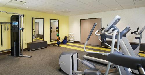 a gym with cardio equipment in a room with yellow walls at CityFlatsHotel - Grand Rapids, an Ascend Collection Hotel in Grand Rapids
