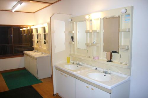 a bathroom with two sinks and a large mirror at Futago Cabin in Minami Uonuma