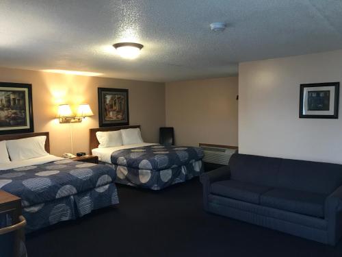 a hotel room with two beds and a couch at Moonlite Motel in Niagara Falls