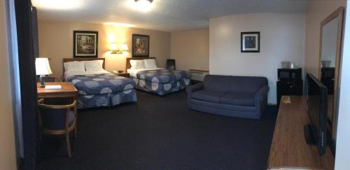 a hotel room with a bedroom with two beds and a chair at Moonlite Motel in Niagara Falls