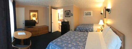 a hotel room with two beds and a television at Moonlite Motel in Niagara Falls