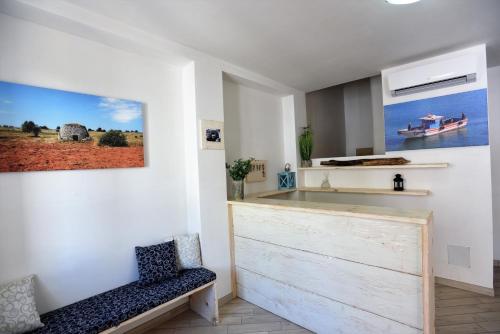 una cocina con un banco y una pintura en la pared en Camere Le Vie di Omero, en Torre dell'Orso