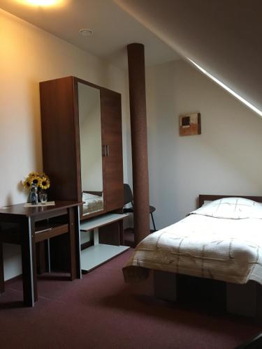 a bedroom with a bed and a desk and a mirror at Hotel Magnolia in Kielce