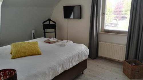 - une chambre avec un lit doté d'un oreiller jaune et d'une fenêtre dans l'établissement Halte 46 Weert, à Weert