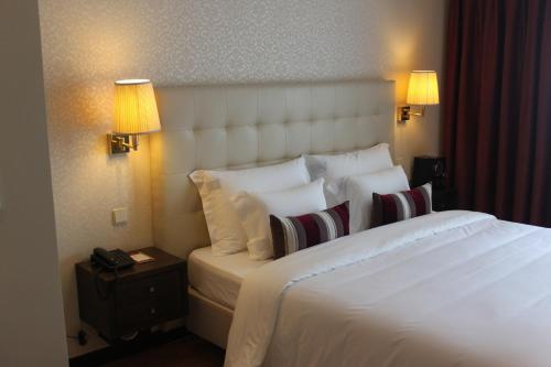 a hotel room with a large white bed with pillows at Hotel Suave Mar in Esposende